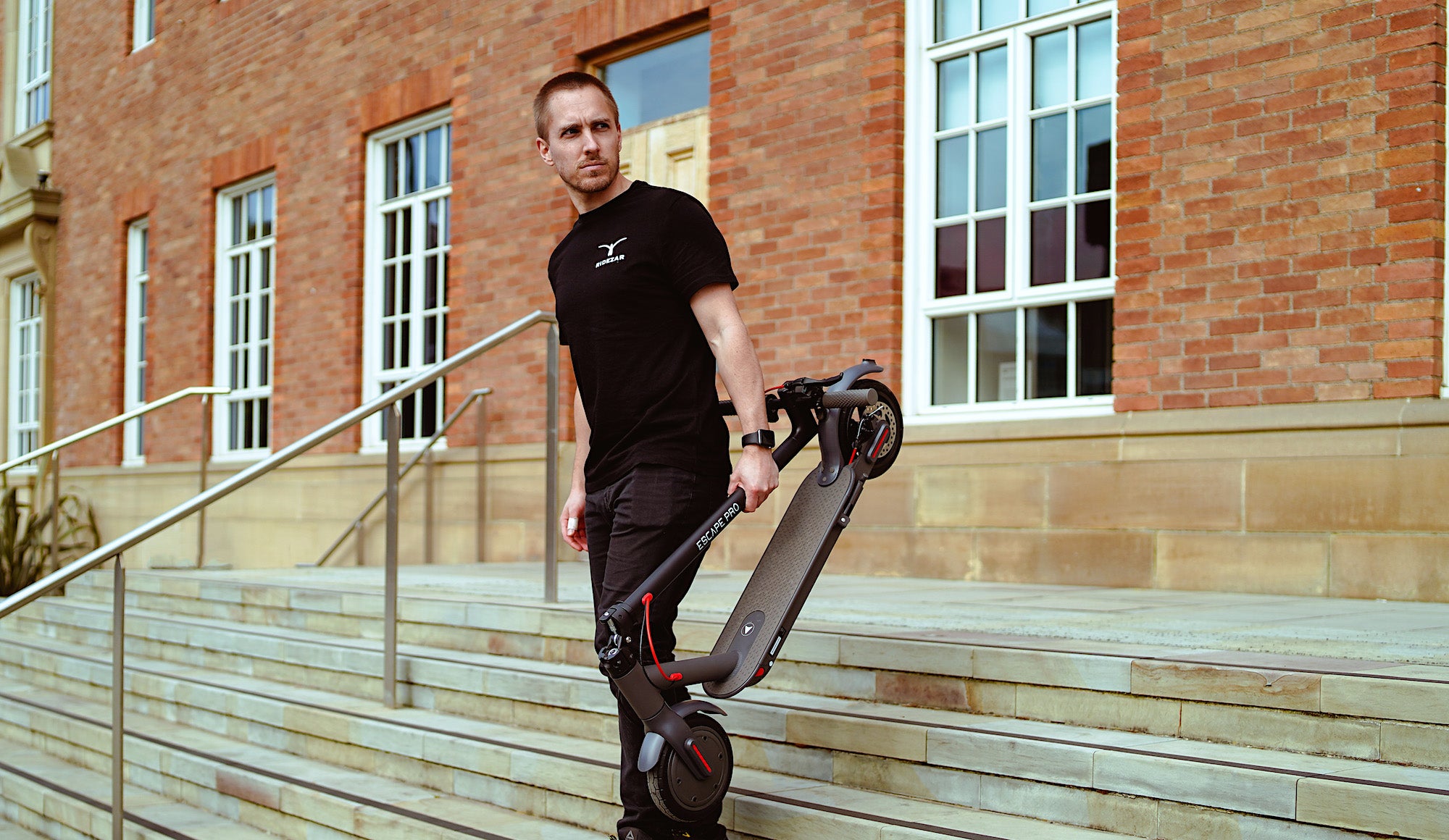 Male in Ridezar Black T-shirt. click and collect available for all electric scooters.