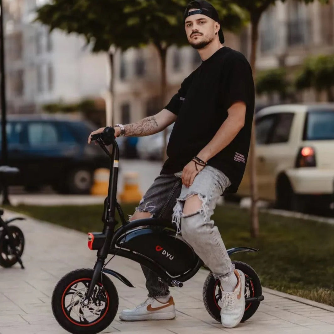 Man Sitting On A DYU D3F Mini Electric Folding Bike