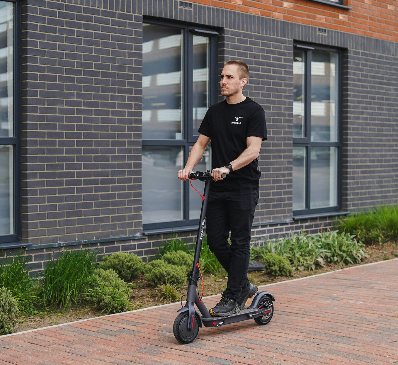 Male riding an Escape pro 2 electric scooter.